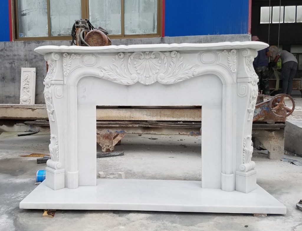 Cream classical beige marble fireplace with heraldic crest — trending warmer stone palette